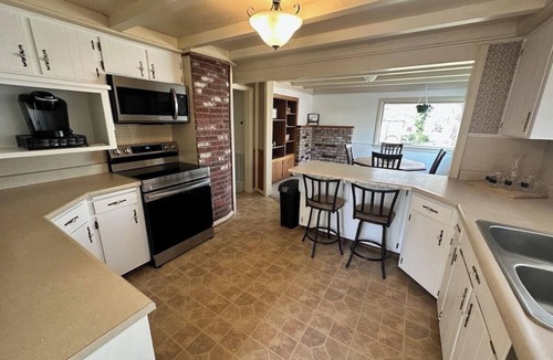 Medford House | Bring everyone together while enjoying the privacy of three separate living spaces. This unique Medford retreat features a spacious main home, two private guest homes, a seasonal pool, hot tub, fully equipped kitchens, and room for the whole family.