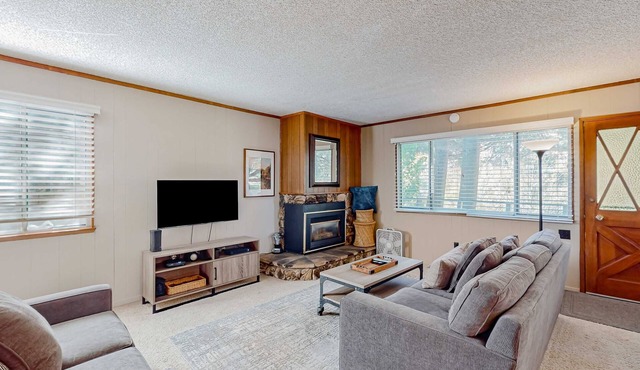 Classic central cabin near river with large tree-lined deck, grassy yard & gym